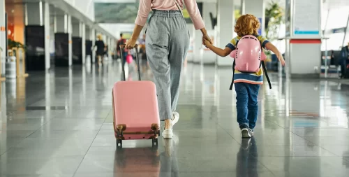 woman-guiding-a-kid-through-an-airport-hall-2026-01-09-00-45-27-utc